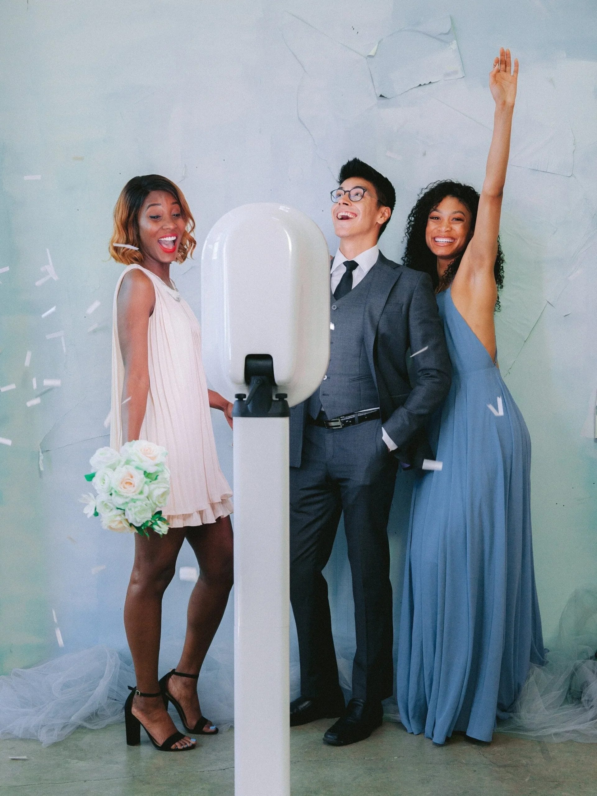 Guest enjoying a photo session in a modern open-air photo booth with glamorous lighting and custom props at a wedding reception.