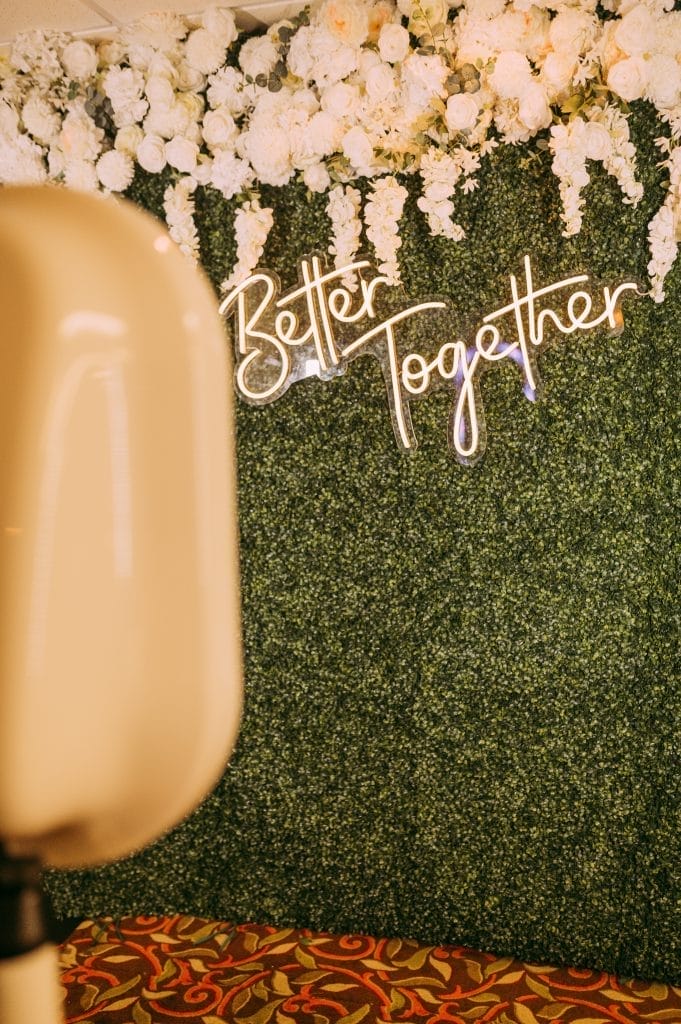 Glamorous photo booth backdrop setup with sequin wall and neon signage at an Ann Arbor wedding event.